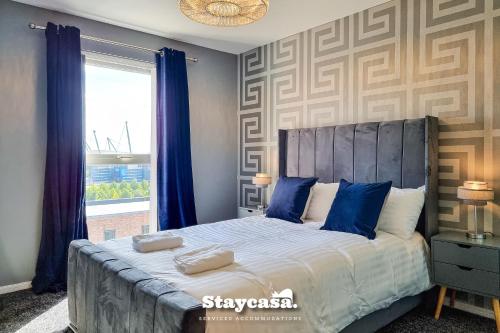 曼彻斯特Luxury 1 Bed Apartment Beautiful View With Parking的一间卧室配有一张带蓝色枕头的床和一扇窗户。