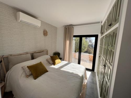 巴利-略夫雷加Villa Torre Cal Sada的一间卧室配有一张带黄色枕头的床和一扇窗户