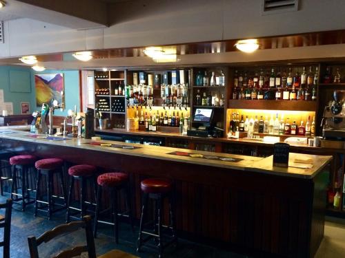 洛哈尔什教区凯尔高地Kintail Lodge Hotel的酒吧设有酒吧凳和酒瓶
