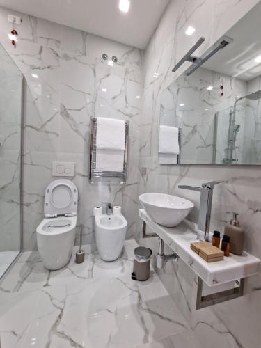 罗马Cuma Suites的白色的浴室设有卫生间和水槽。