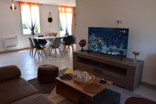 Saint-Père-sur-Loireô temps de l'escapade的客厅配有平面电视和桌子。
