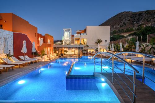 赫索尼索斯Esperides Resort Crete, The Authentic Experience的一座带桌椅的游泳池位于大楼旁