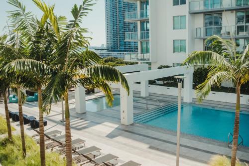 迈阿密Luxury Oceanview Studio at Miami Design District的从棕榈树建筑的阳台上可欣赏到游泳池的景色