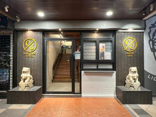 哥打京那巴鲁CU Boutique Hotel的前面有两座雕像的建筑