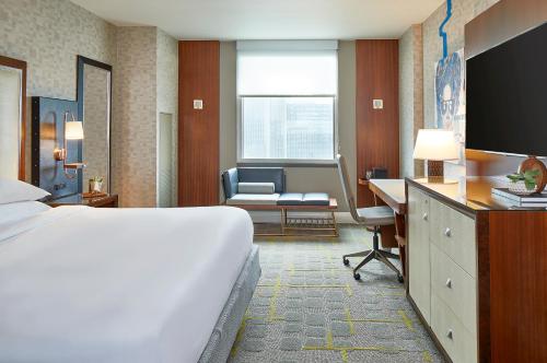 亚特兰大亚特兰大中城万丽酒店的酒店客房配有一张床、一张桌子和一把椅子。