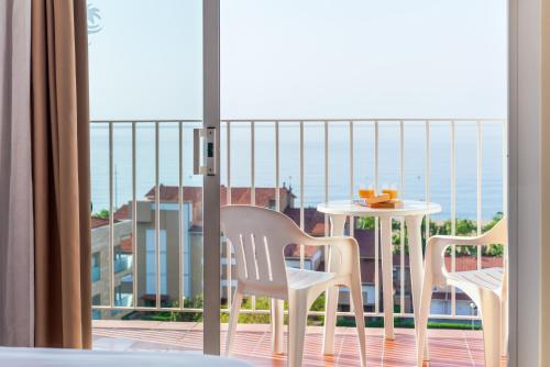 卡里拉Checkin Catalonia的海景阳台上配有两把椅子和一张桌子