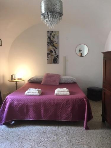 奥里斯塔诺Da Julia的一间卧室配有一张紫色床和两条毛巾