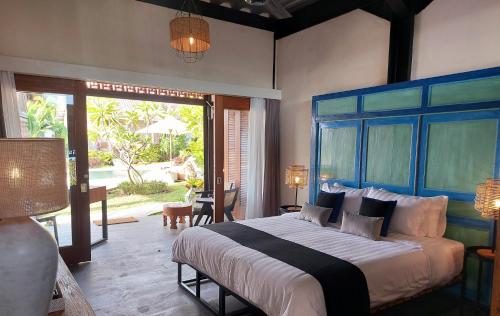 DalungSpaces Bali的一间卧室配有一张大床和蓝色床头板