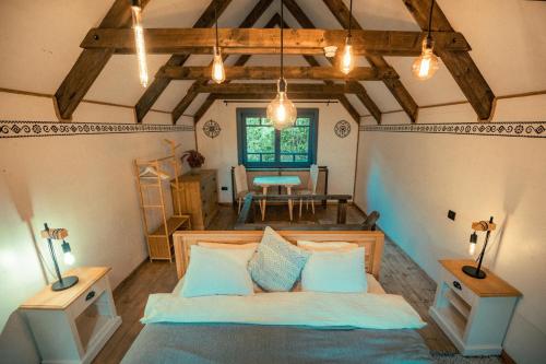Sub PiatraRaven's Nest - The Hidden Village, Transylvania - Romania的一间卧室设有床、两张桌子和一扇窗户