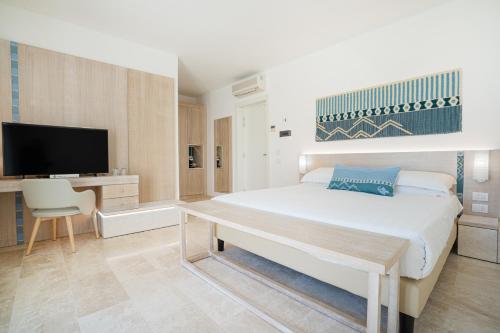 圣特雷莎加卢拉克鲁西亚酒店的一间卧室配有一张床、一张书桌和一台电视。