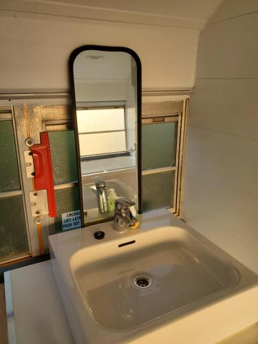 BassengeThe School Bus的浴室水槽和上面的大镜子