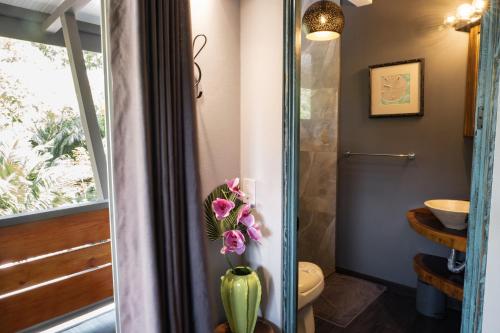 乌维塔Hotel FAREMITI Uvita的浴室内装有鲜花的花瓶