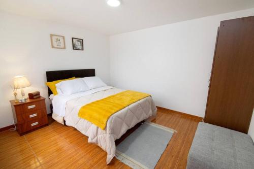 利马Acogedor apartamento cerca al mar.的一间卧室配有一张黄色毯子床