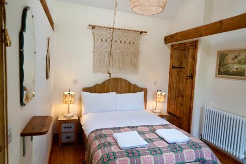 彻奇斯特雷顿Nest Holiday Hideaway Wren Cottage Stunning Area!的一间卧室配有一张床和两张台灯。