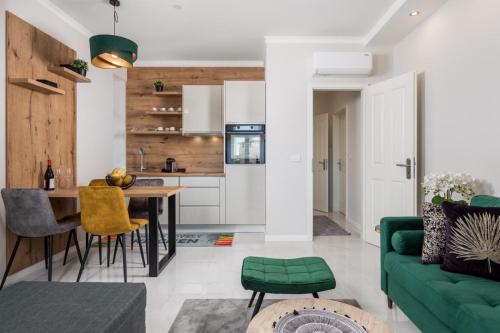 洛夫兰Deluxe Kvarner 2的厨房以及带绿色沙发的客厅。