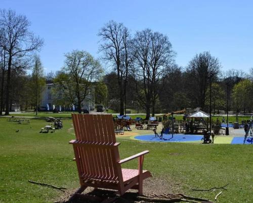 阿灵索斯Attefallshus Alingsås / Dammen.的公园内的木椅,带游乐场