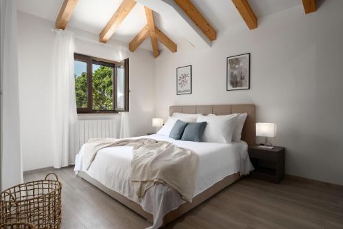 波雷奇Casa Pinia with outdoor jacuzzi的白色的卧室设有一张大床和一个窗户
