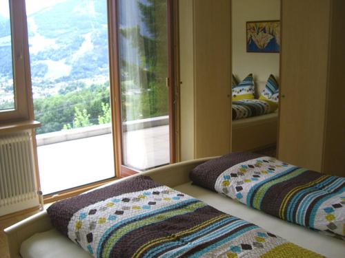 利恩茨Ferienwohnung Jeller的客房设有两张床和大窗户。