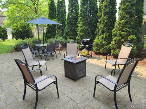 基奇纳希尔顿基奇纳汉普顿酒店及套房的庭院配有椅子和一张带烧烤架的桌子。