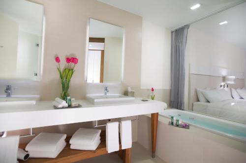 巴亚尔塔港Krystal Grand Puerto Vallarta - All Inclusive的浴室设有2个水槽和1个带粉红色花卉的浴缸。