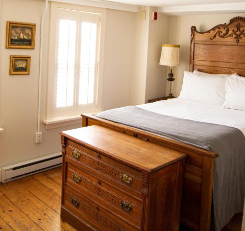 查尔斯敦The General Stanton Inn的一间卧室配有带梳妆台和窗户的床。