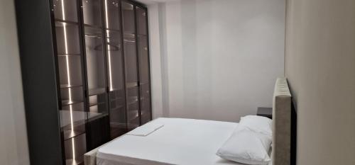 地拉那Heart of Tirana Apartment的一间卧室配有一张床和一个木制橱柜