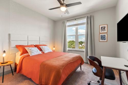 坦帕Luxury Condo in Ybor City Tampa w/Pool access的一间卧室配有一张床、一张书桌和一个窗户。