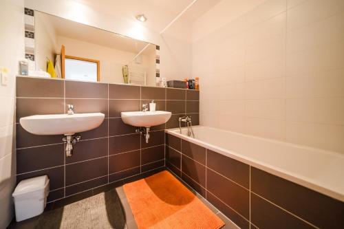 布拉迪斯拉发Comfy condo on the 20th floor & FREE parking的浴室配有两个盥洗盆和浴缸。