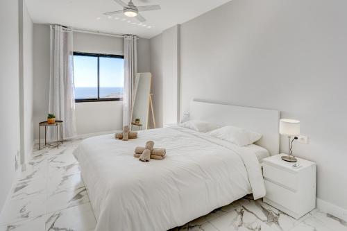 帕莱索海滩Prime apartments Club Paraiso Ocean view的一间白色卧室,配有一张带两个泰迪熊的床