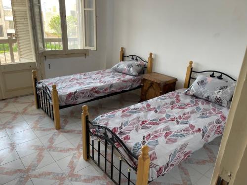 阿莱曼قرية جرين بيتش的一间卧室设有两张单人床和一个窗户。