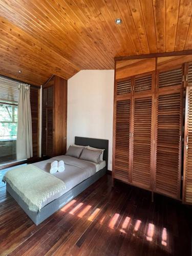 阿鲁沙Olosiva Oasis的一间卧室设有一张床和木制天花板