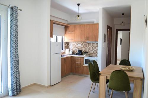 基利尼Α & D Perikleous Apartments的厨房以及带桌椅的用餐室。