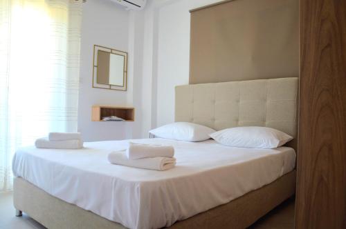 基利尼Α & D Perikleous Apartments的卧室配有白色床和毛巾