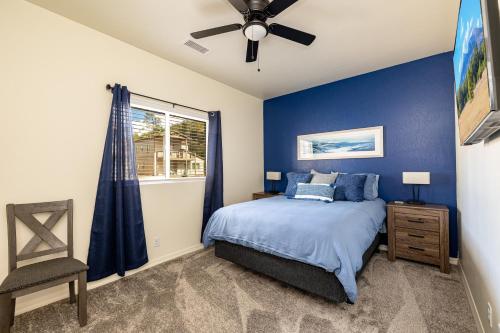 弗拉格斯塔夫Mt. Elden Adventure的一间卧室设有蓝色的墙壁和一张带吊扇的床。