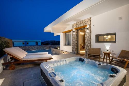 阿彻奇洛斯Lithos Luxury Villa的房屋后院的按摩浴缸