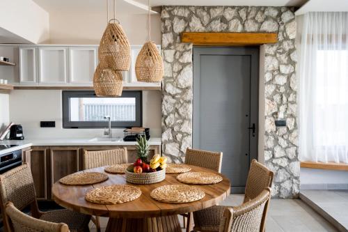 阿彻奇洛斯Lithos Luxury Villa的厨房以及带木桌和椅子的用餐室。