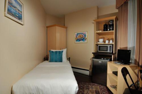 多伦多胜利大厦宾客酒店的小房间设有床铺和微波炉