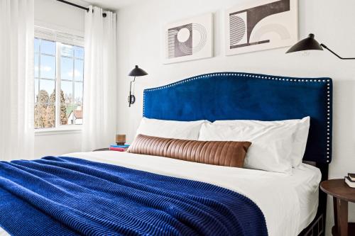 丹佛Bright & Modern Retreat - King Beds - Sloans Lake的蓝色和白色的床,带有蓝色床头板