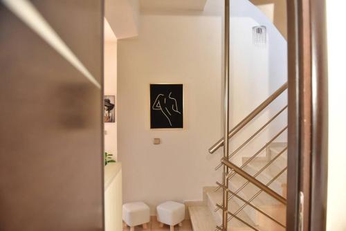 卡特罗斯Villa Emmanuel的走廊上设有楼梯和两个凳子