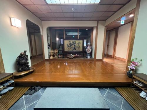 笛吹市Fukuro no Oyado Shinkan - Vacation STAY 59600v的一间铺有木地板的客房和一间配有花瓶的房间