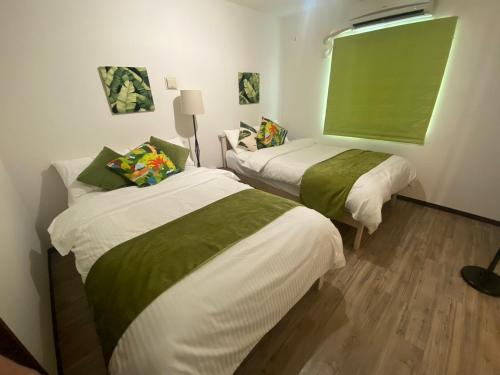 石垣岛Monstera - Vacation STAY 60812v的客房 - 带两张带绿色和白色床单的床