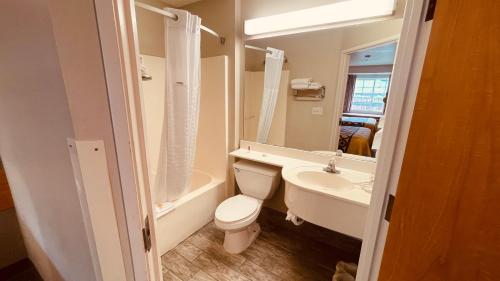 米德瓦尔Royal Inn Midvale的浴室配有卫生间、盥洗盆和浴缸。