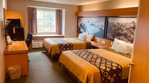 米德瓦尔Royal Inn Midvale的酒店客房设有两张床和电视。
