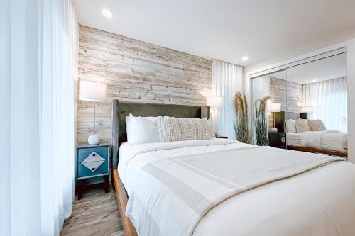 蒙特朗布朗Le PanoramiK by Gestion ELITE的卧室配有白色的床和木墙