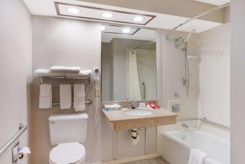格林伍德SureStay Plus Hotel by Best Western Greenwood的浴室配有卫生间、盥洗盆和浴缸。
