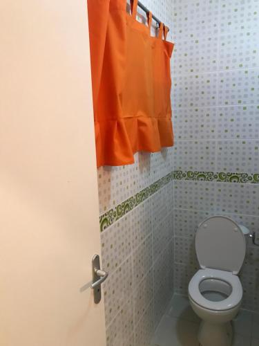 马罗尼河畔圣洛朗Discrétion的浴室配有卫生间和橙色窗帘