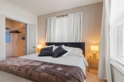 坦帕Luxury Condo in Ybor City Tampa w/Pool access的卧室配有一张带两个枕头的大白色床