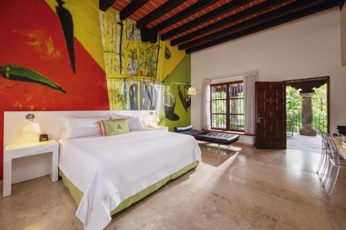 库埃纳瓦卡Anticavilla Hotel Restaurante & Spa的卧室配有白色的床和色彩缤纷的墙壁