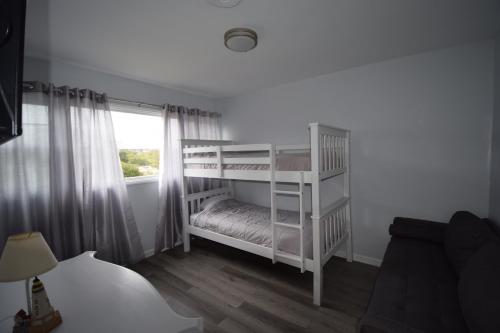翡翠岛Oceanfront vacation property - West的窗户客房内的一张白色双层床