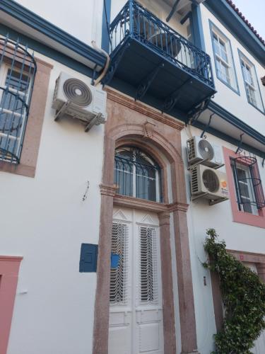 艾瓦勒克Mimosa House Ayvalık的一座带白色门和阳台的建筑